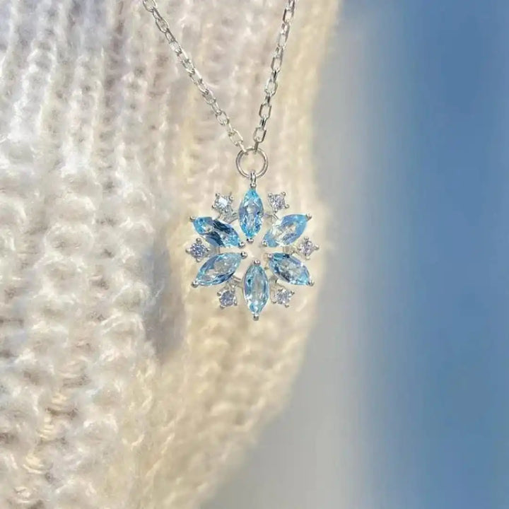 Weißgoldene Blüten-Anhänger-Halskette mit blauer Schneeflocke